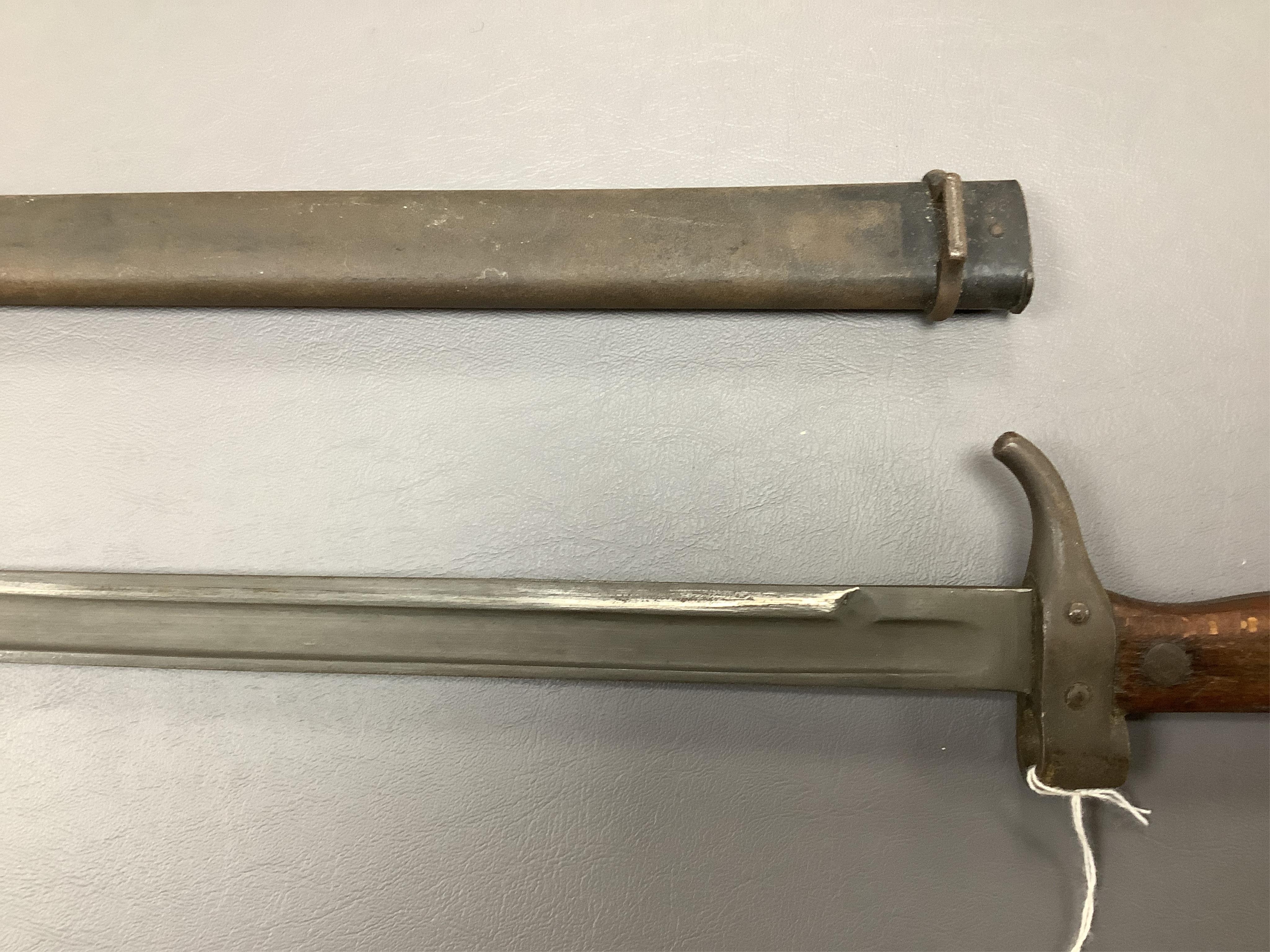 A First World War Turkish army officer’s sword, with pipe back blade, regulation iron guard pierced with crescent and moon, chequered horn grips, in its iron scabbard, together with an unidentified bayonet in its scabbar